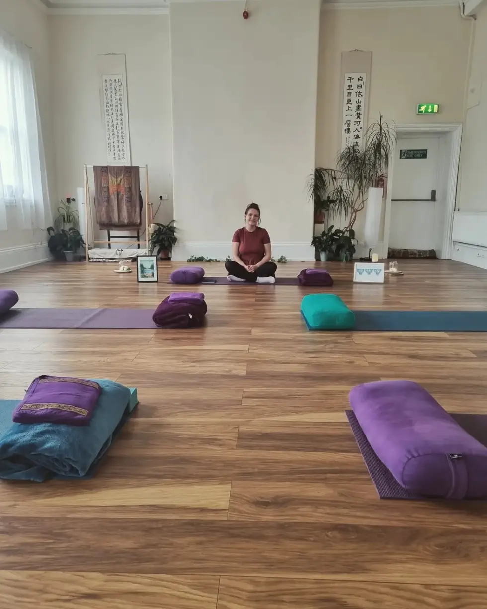 A calm studio space laid out with mats, bolsters and blankets ready for a group session